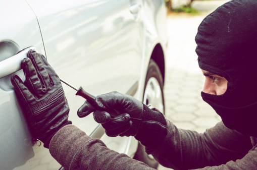 thief trying to break into a car